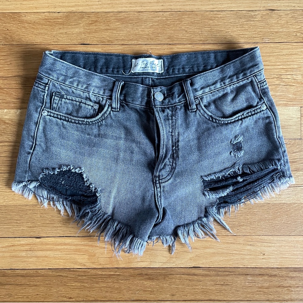 Free People “Loving Good Vibrations” distressed cutoff denim shorts. Carbon.